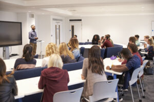 University students study in a classroom with African American male lecturer