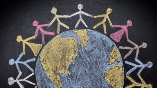 Chalk drawing of stick figures encircling the world.