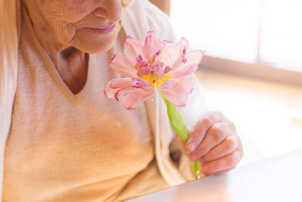 Elderly woman holding a flower