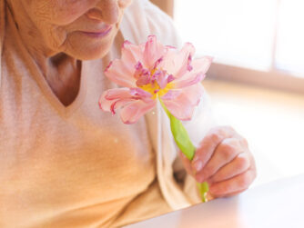 Elderly woman holding a flower