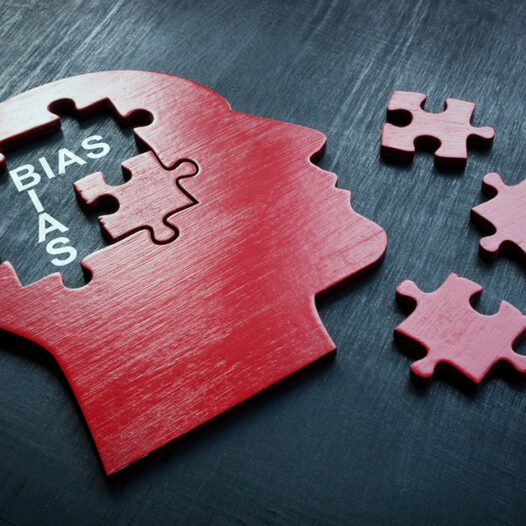 Cut out shape of a head with puzzle pieces missing from the mind. With bias written to indicate the bias of mental health diagnosis.