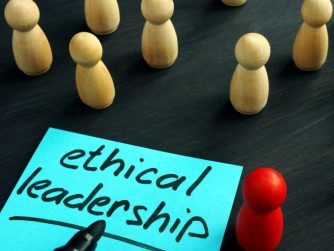 Ethical Leadership written on a sticky note surrounded by white pegs with one red peg standing out from the crowd.