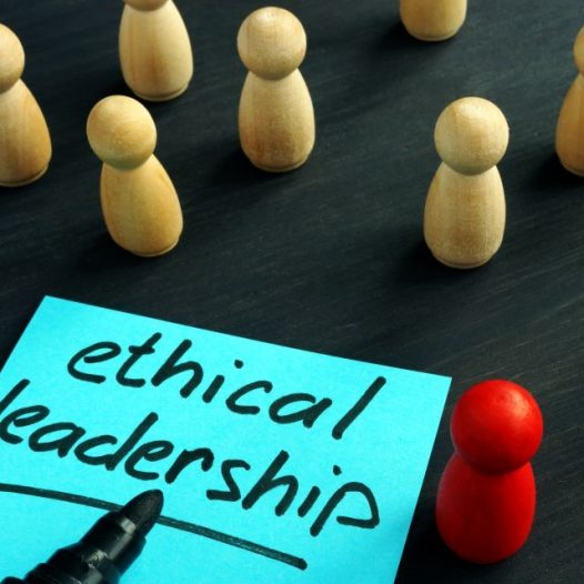 Ethical Leadership written on a sticky note surrounded by white pegs with one red peg standing out from the crowd.
