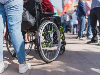 Person in wheelchair trying to navigate through a crowd.