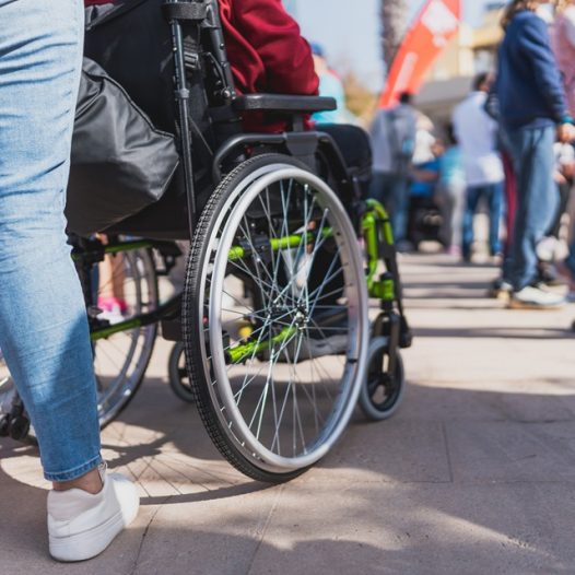 Person in wheelchair trying to navigate through a crowd.